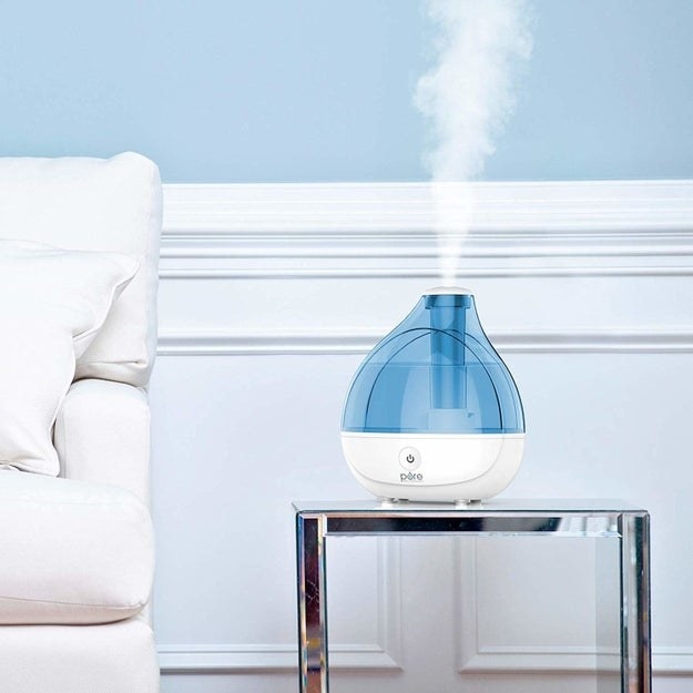 Humidifier placed on table with mist coming from the top