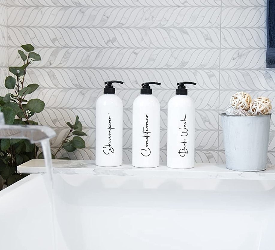 three of the reusable bottles on a bathtub ledge