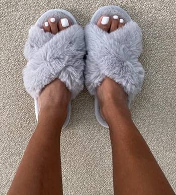 reviewer wearing the gray fuzzy slippers