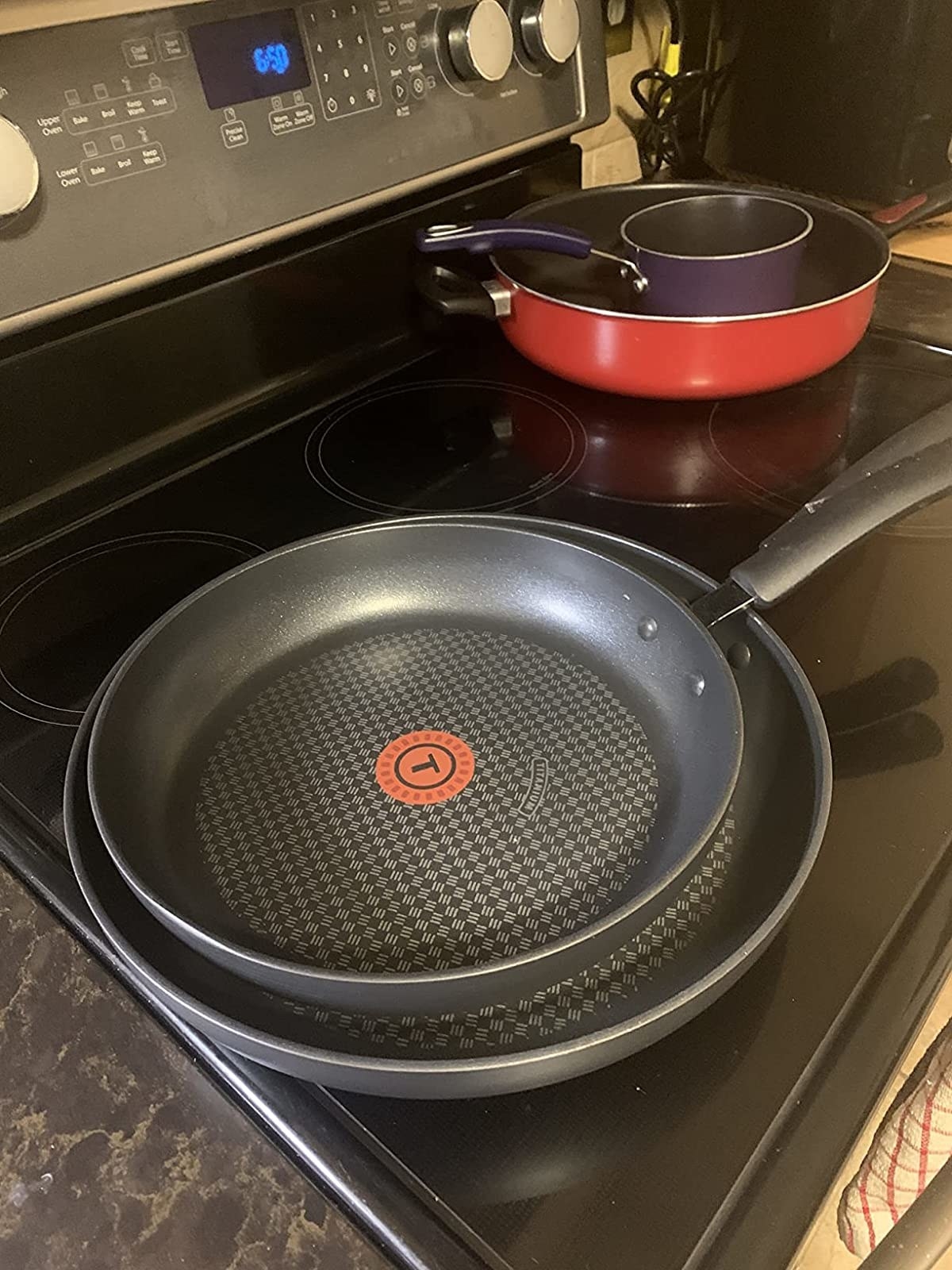 the two black pans stacked on a stove