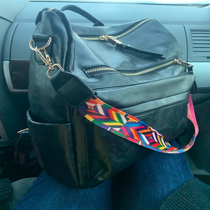 reviewer photo of the black backpack with a colorful strap