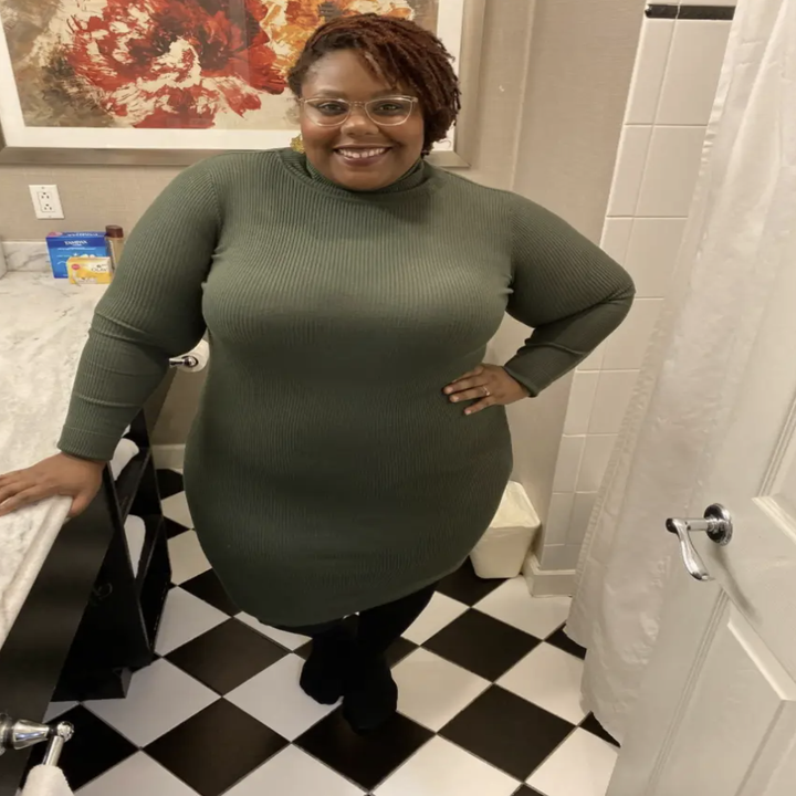 reviewer wearing turtleneck dress in a green color