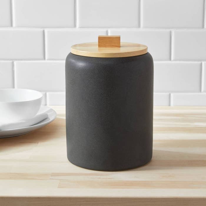 the gray canister with wooden top