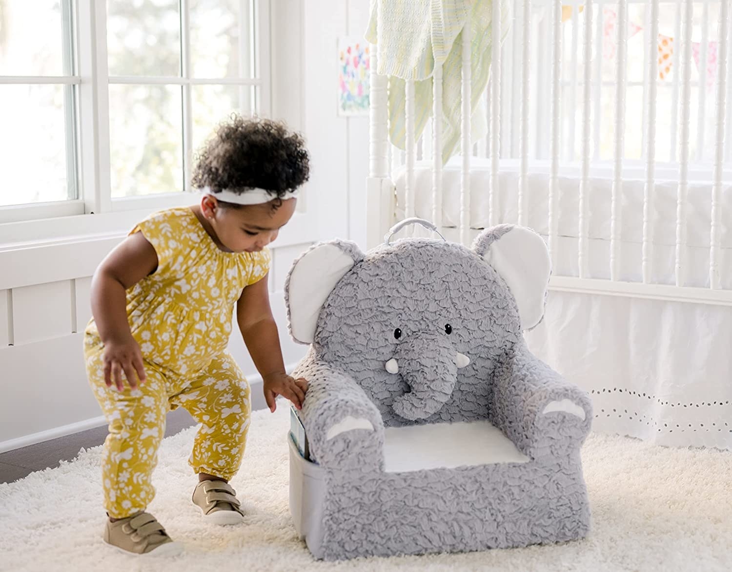 toddler approaching the gray elephant-shaped chair