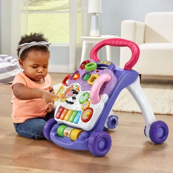 a baby plating with the sit to stand toy