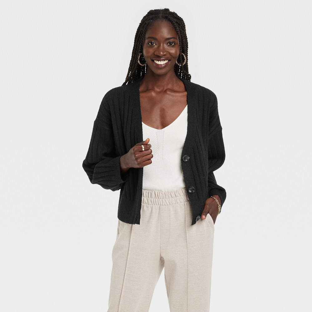 Smiling woman wears comfortable pants and shirt with cardigan thrown over
