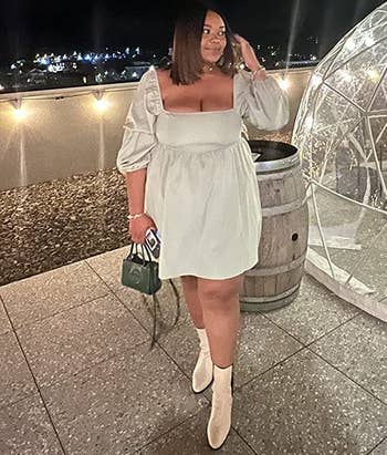 reviewer wearing the white dress with ankle boots