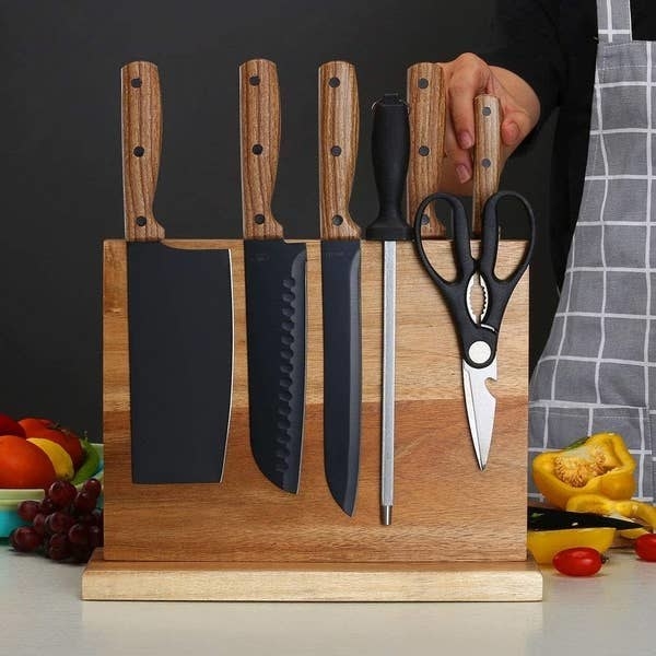 a magnetic knife rack with knifes on it