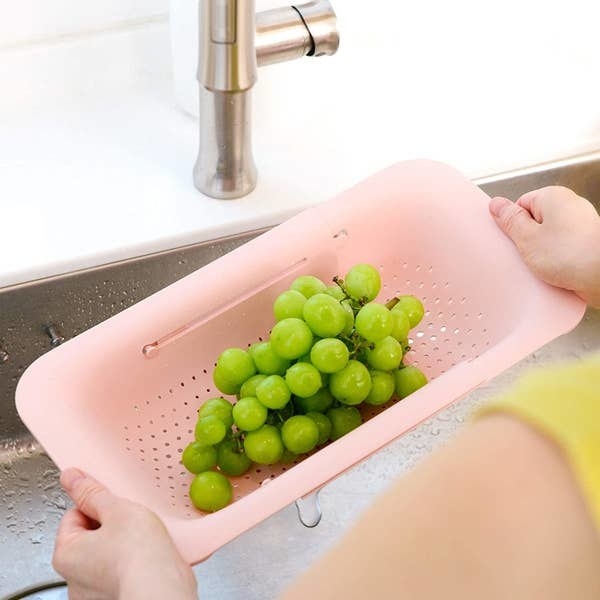 an extendable colander holding grapes