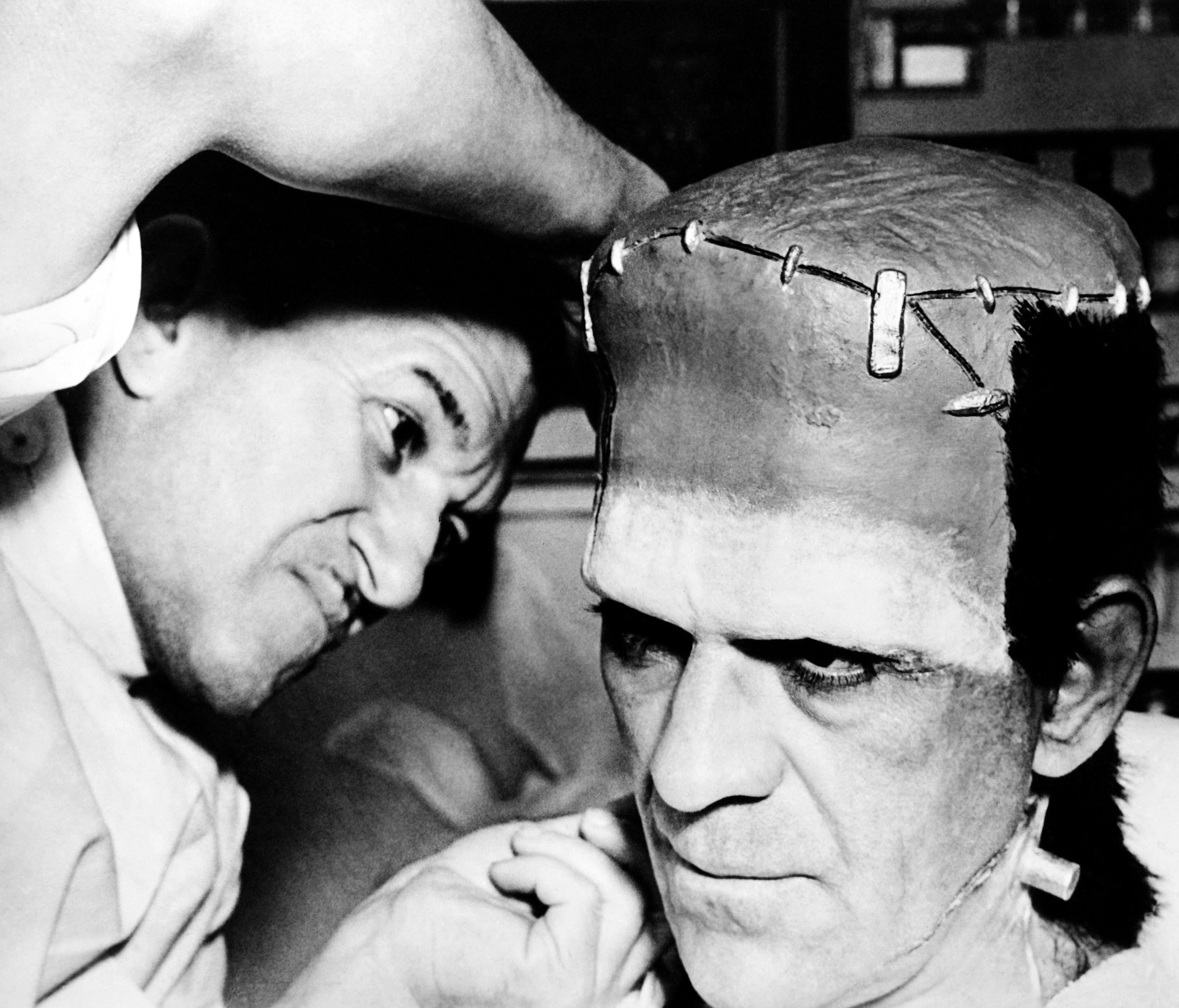 Boris Karloff being worked on by makeup artist Jack Pierce on set