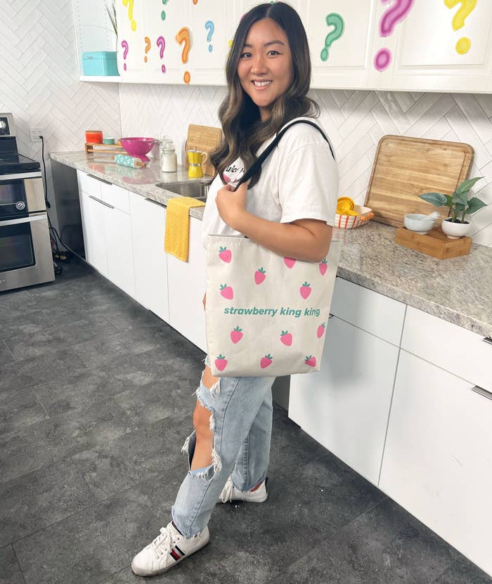 Jasmine holding the tote with blue jeans and a white top