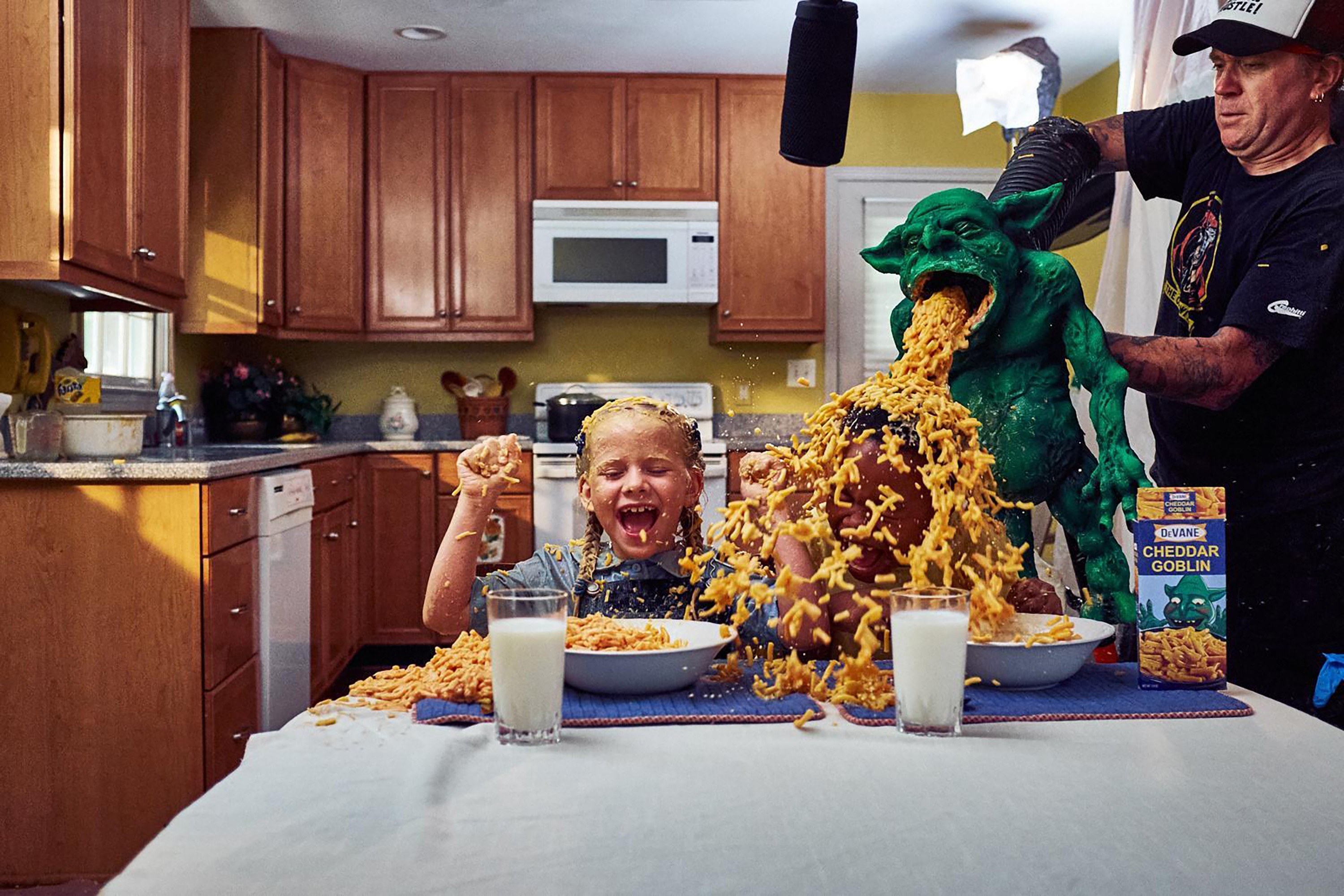 Two children get mac and cheese thrown up on them by a green goblin
