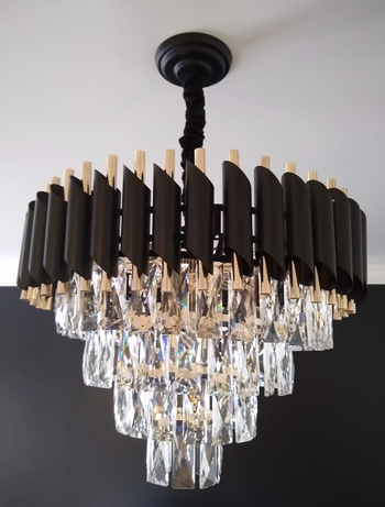 closeup of tiered glass chandelier with black and gold details at top