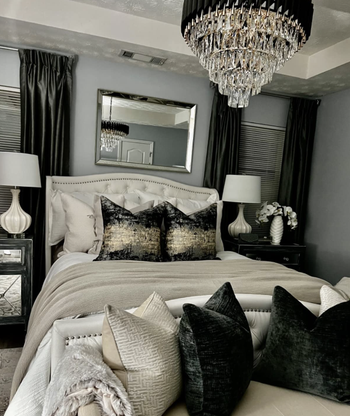 reviewer's bedroom with bedding matching the gold and black chandelier