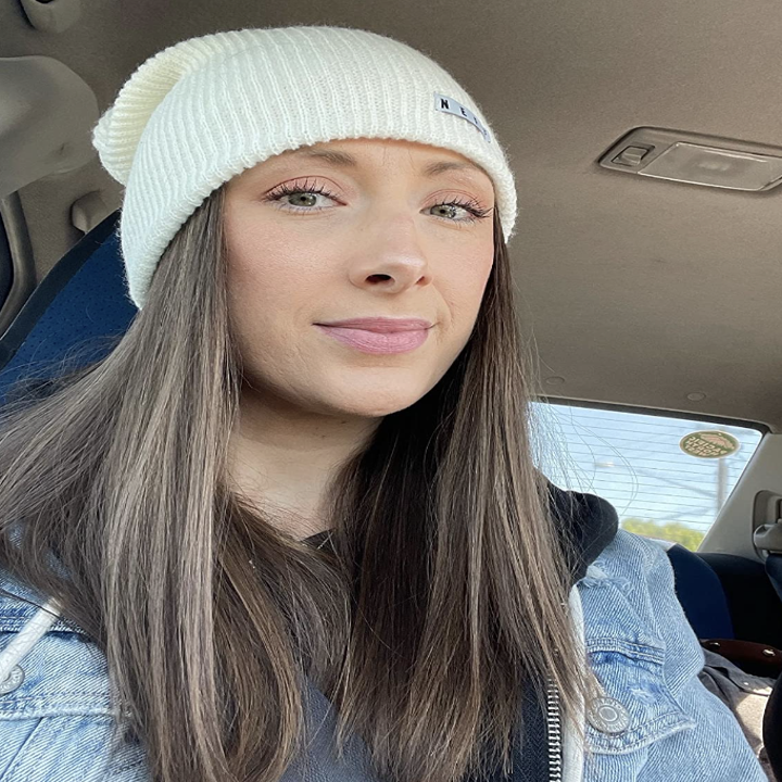 reviewer wearing neff beanie in white while sitting in car