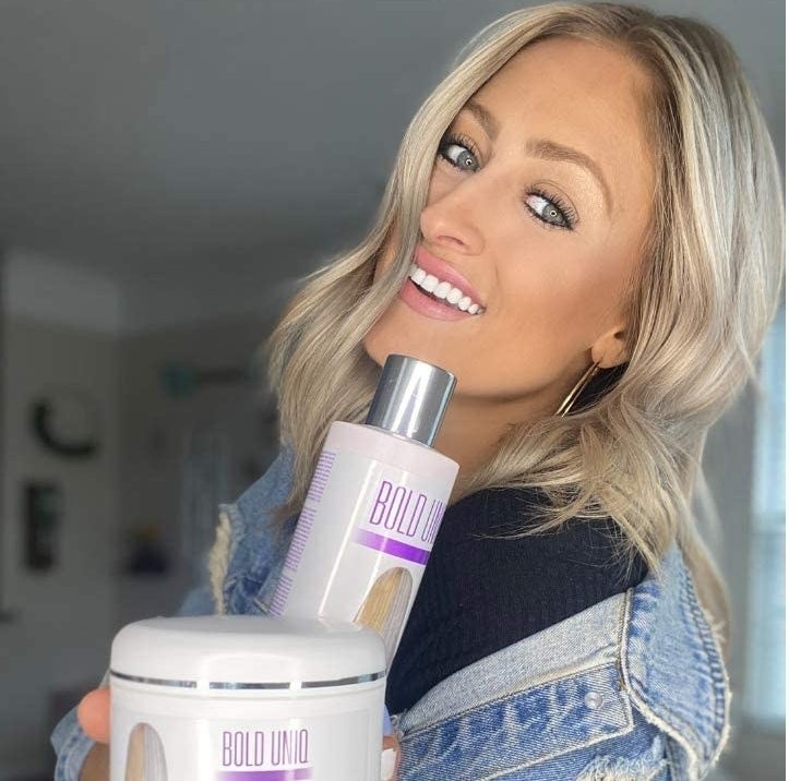 person holding the bottle of shampoo with a tub of hair mask