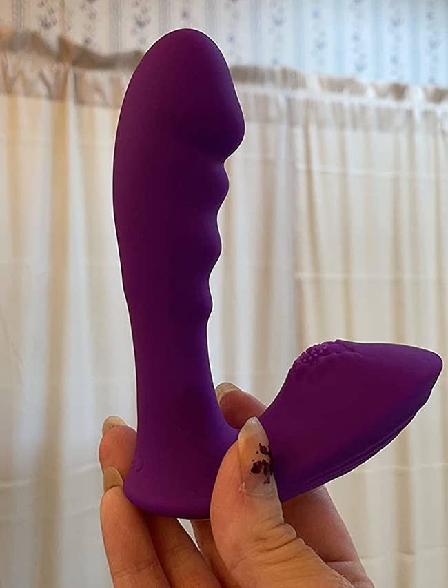 Reviewer holding purple wearable g-spot vibrator