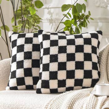 two square pillows on a sofa. they have a checker pattern.