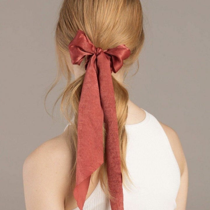 Model from behind showing red scrunchie used to secure a low ponytail