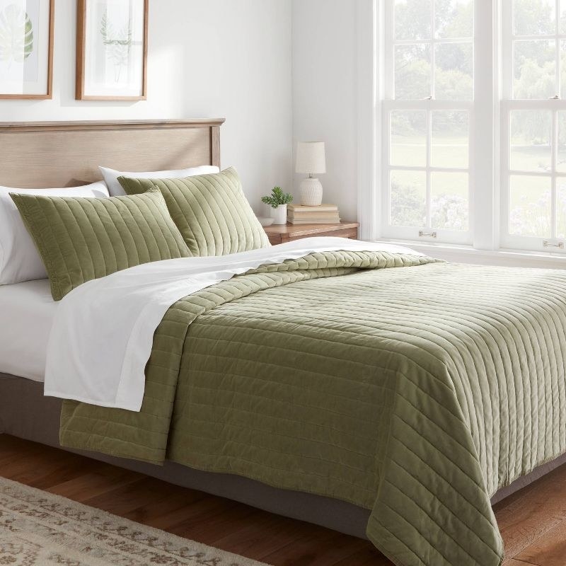 the green velvet quilt on a decorated bed