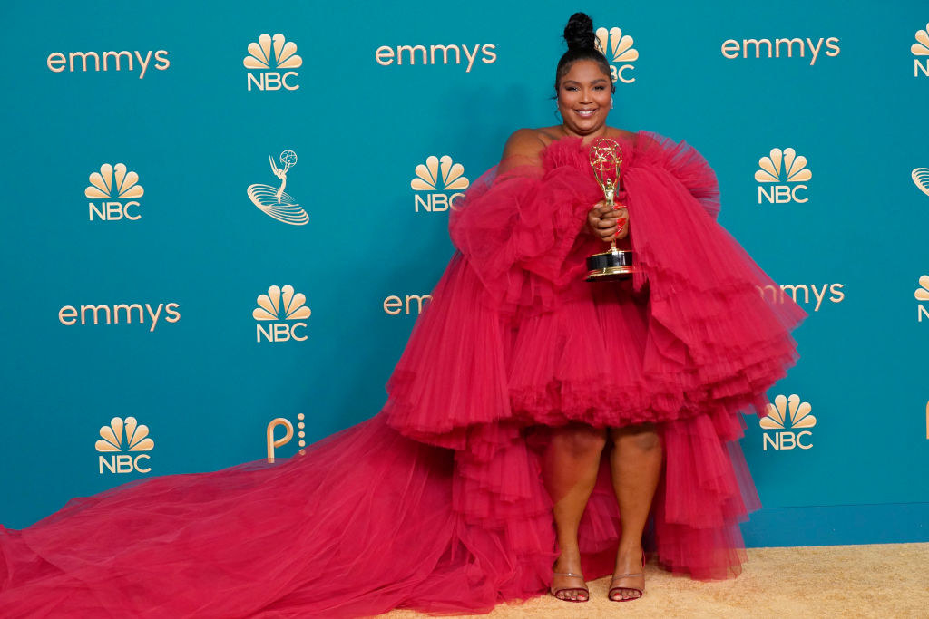 Lizzo holding her Emmy award backstage