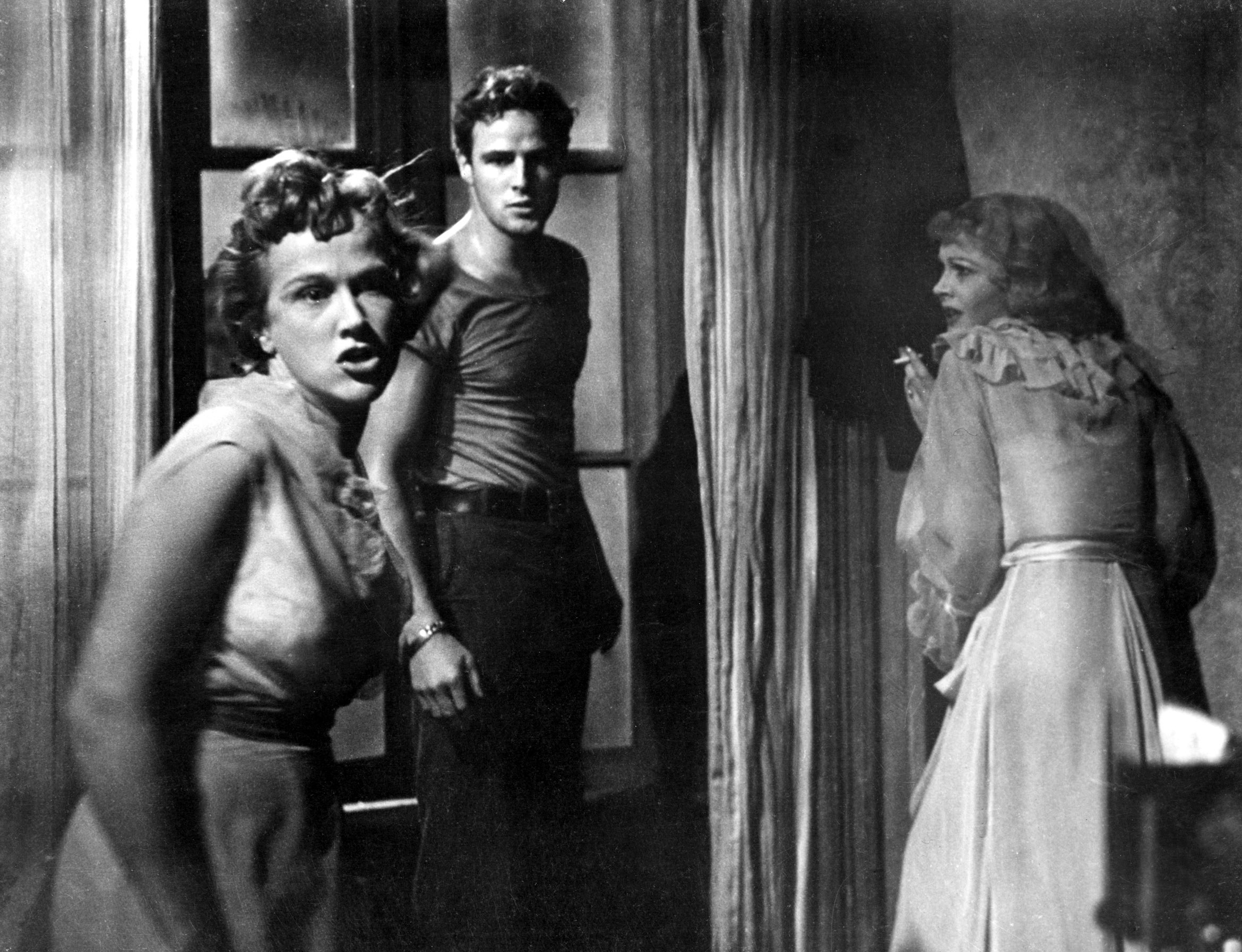 Kim Hunter, Marlon Brando, and Vivien Leigh stand in a room arguing