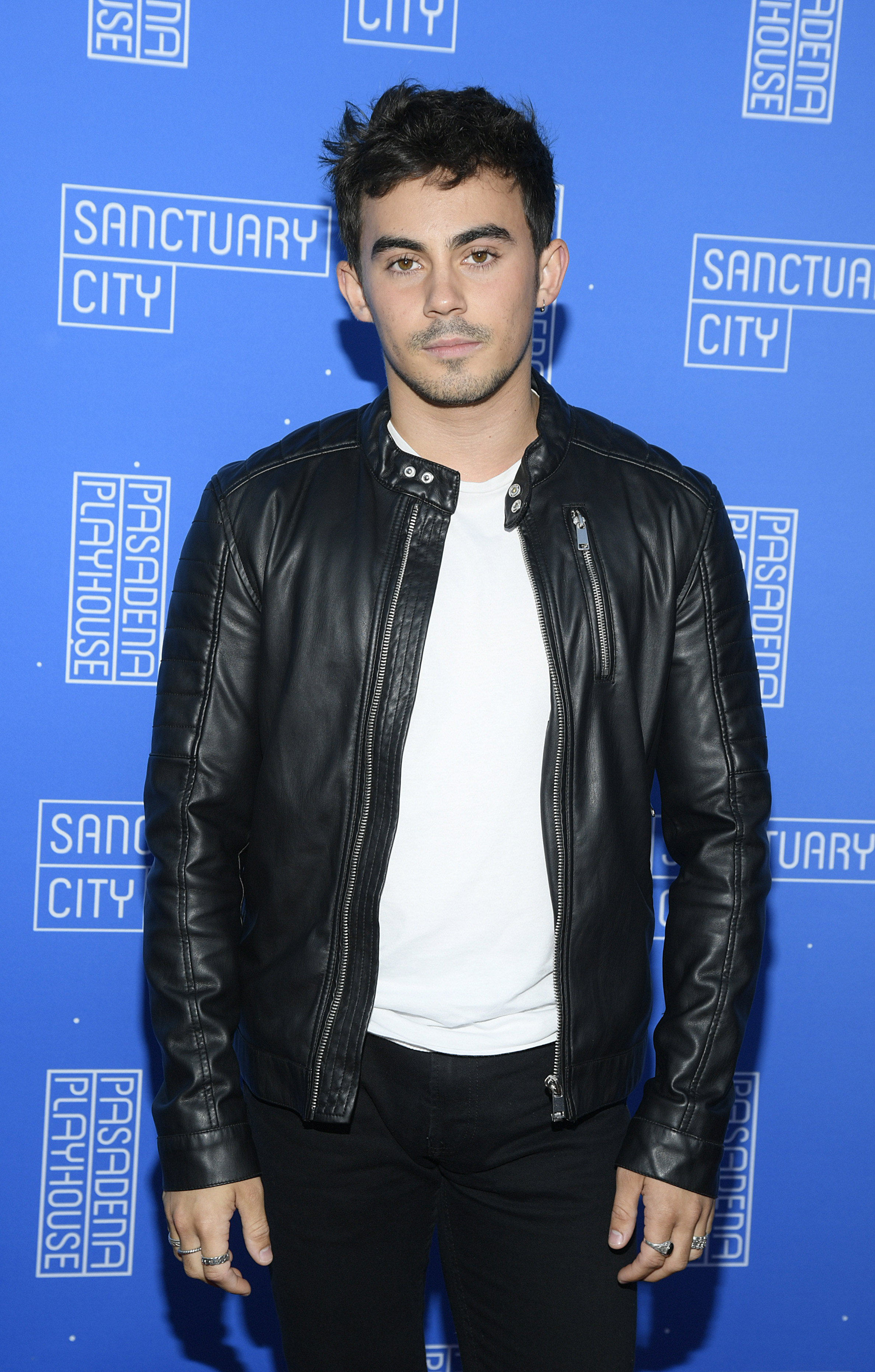 Tyler at an event with messy hair and a leather jacket