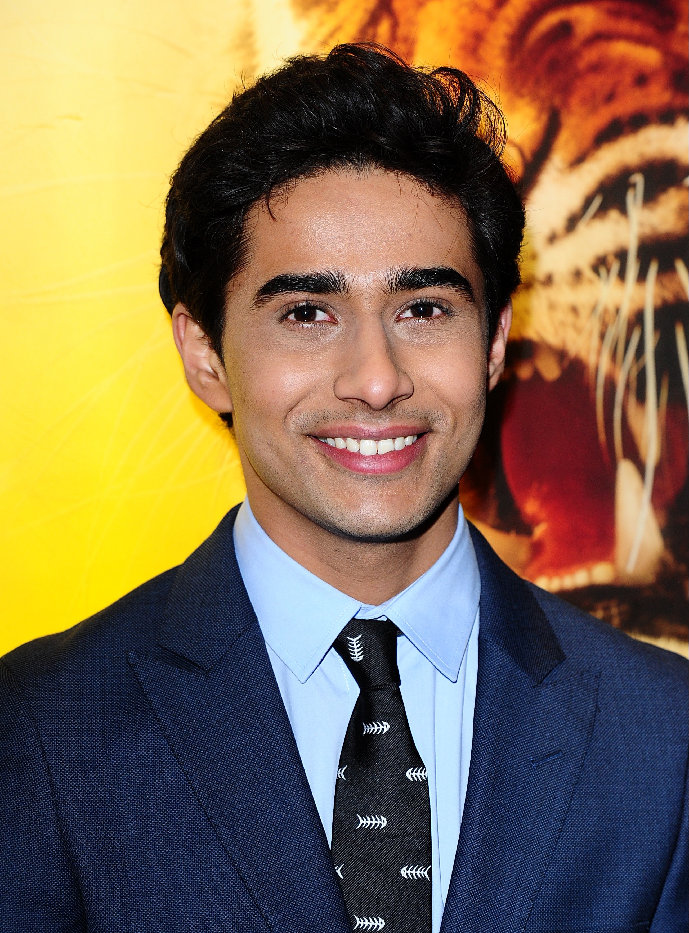 younger Suraj smiling in a suit