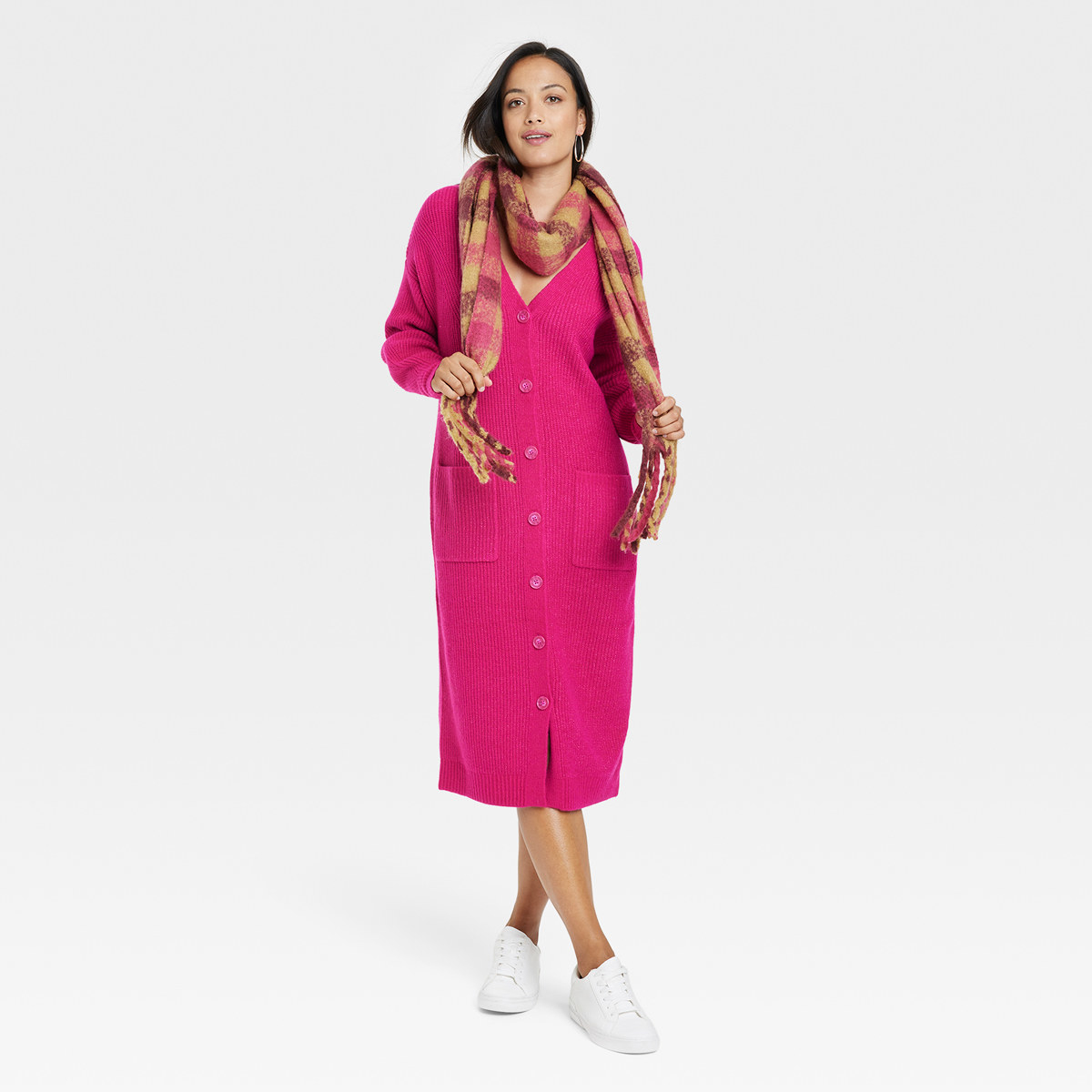 Smiling woman wear long pink sweater dresses paired with scarf and tennis shoes