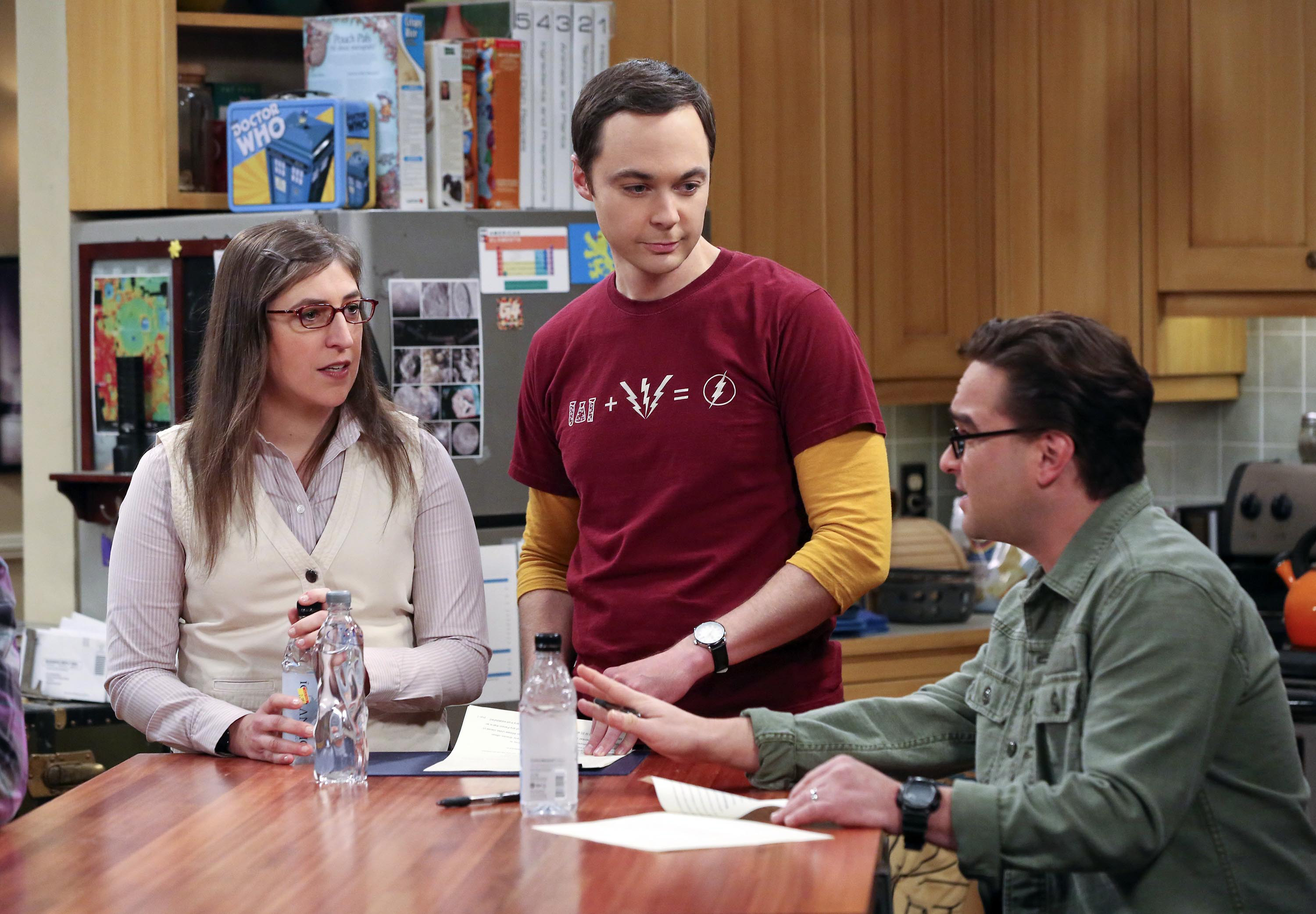 Jim standing with Mayim Bialik and Johnny Galecki during a scene in the kitchen