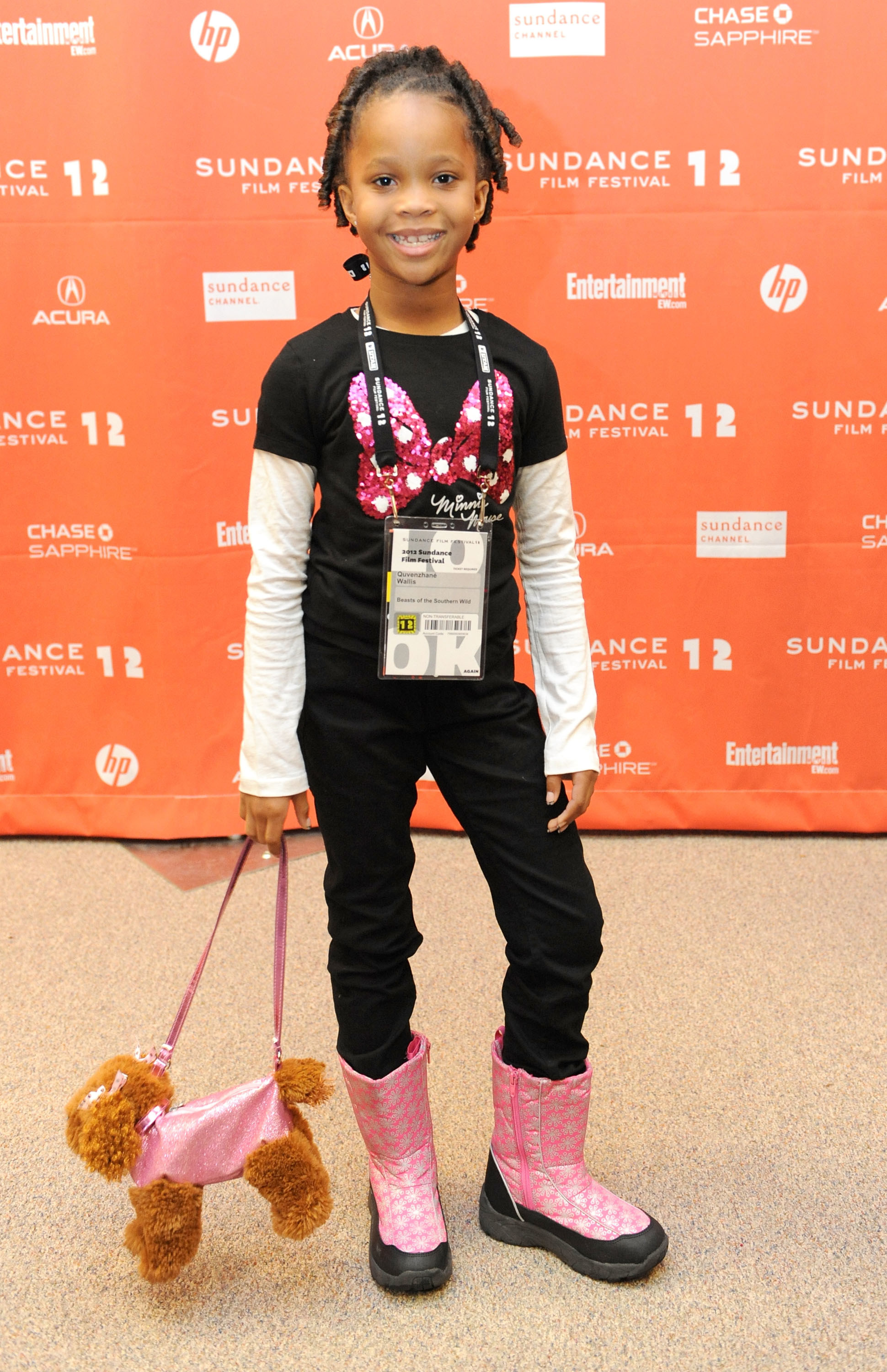 young Quvenzhané with a stuffed dog purse at an event