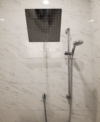 reviewer's shower head in marble shower