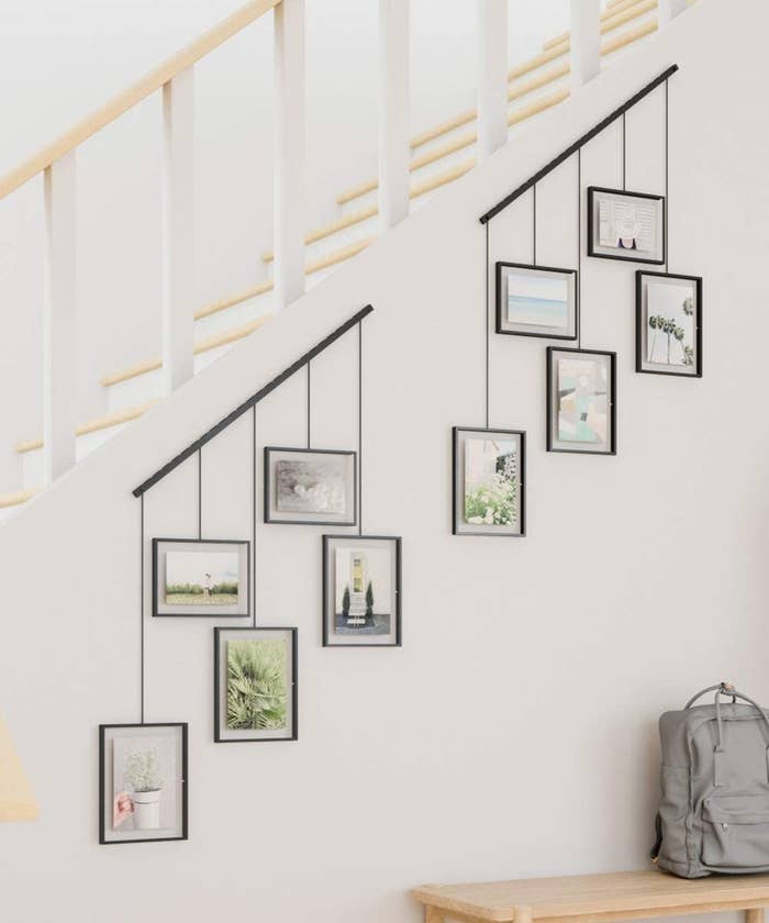 the photo frames hung diagonally along the bottom of a set of stairs