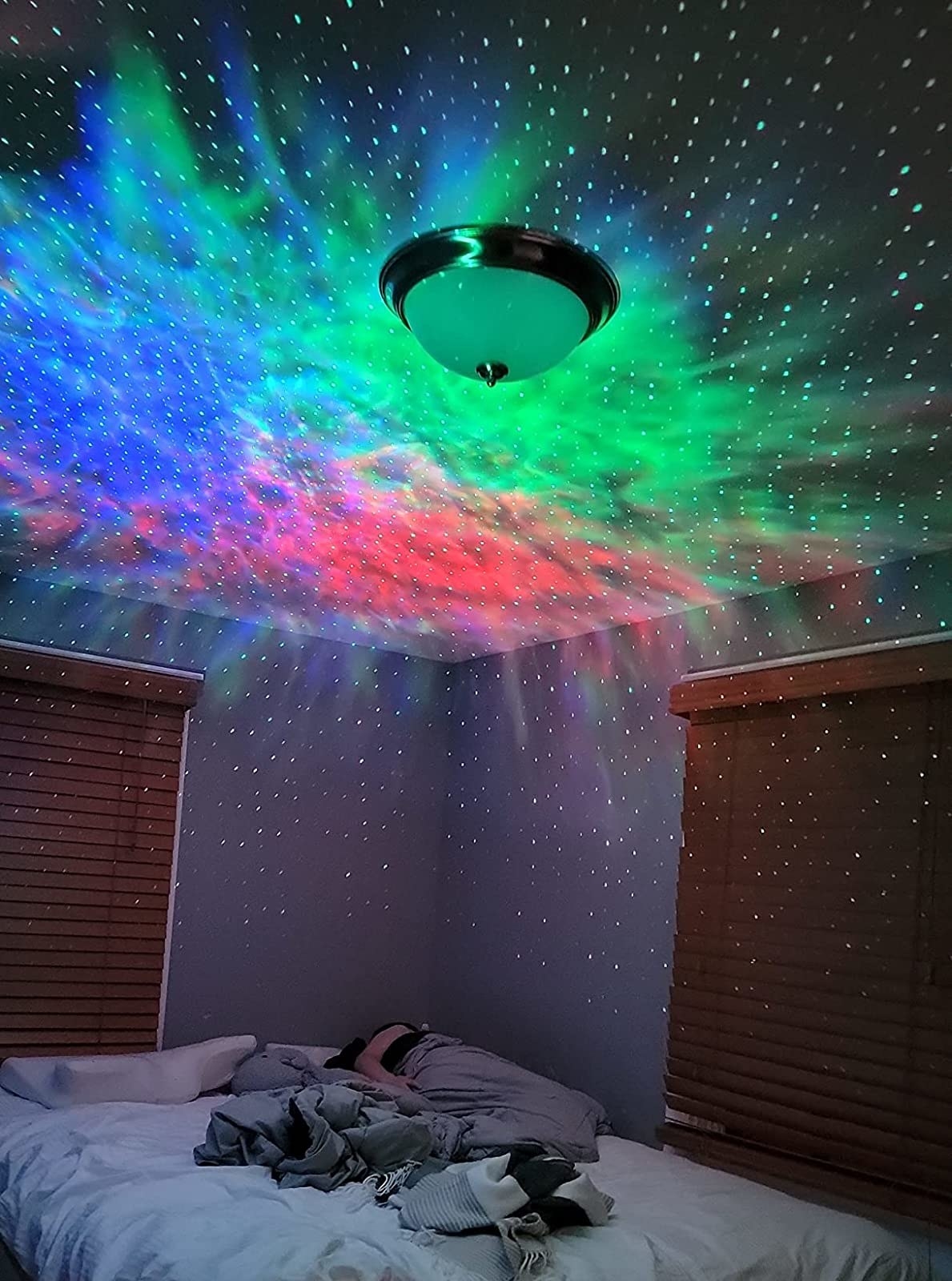 Reviewer&#x27;s bedroom is shown with the light show projected all over the ceiling and walls