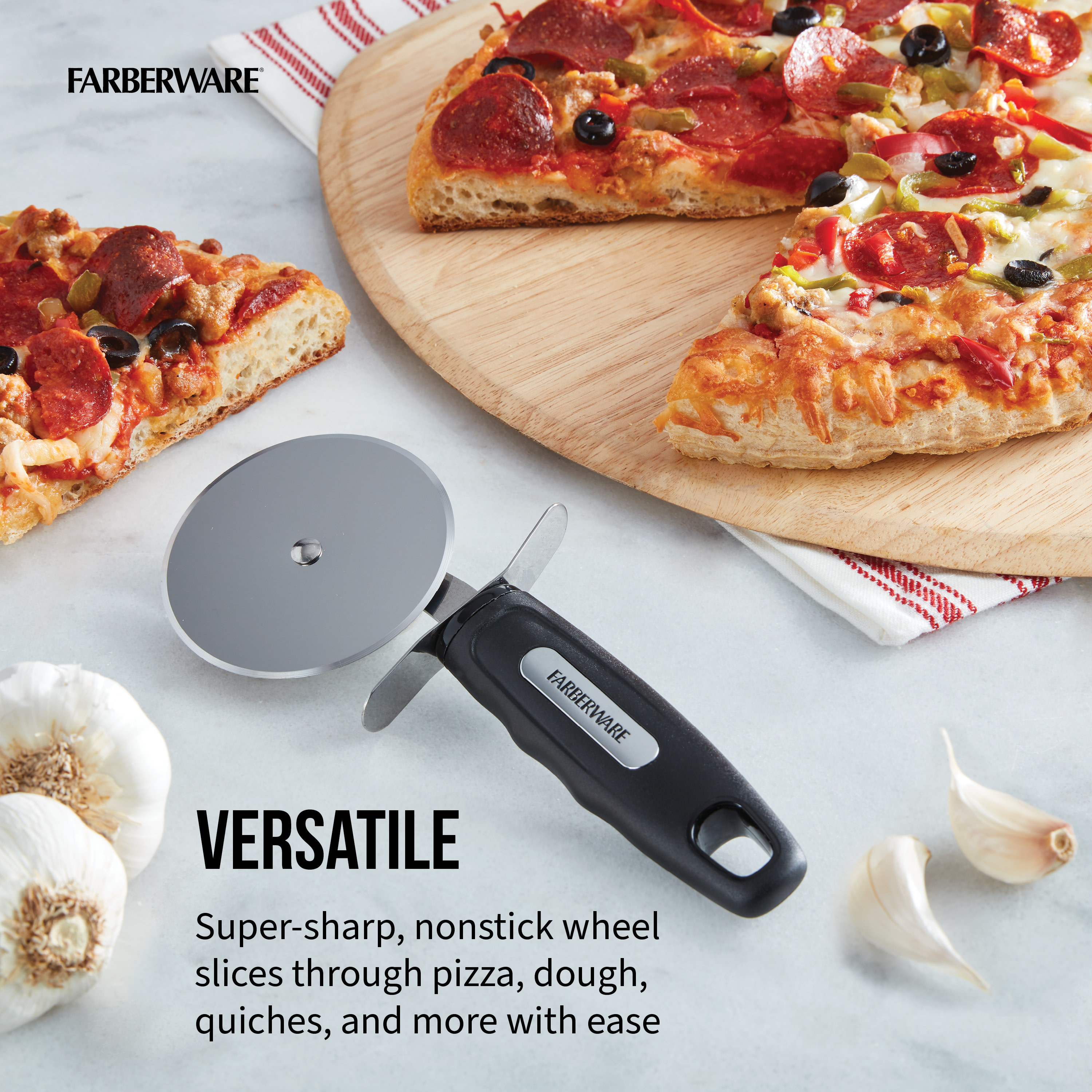 Stainless steel pizza cutter with a black handle next to a pizza