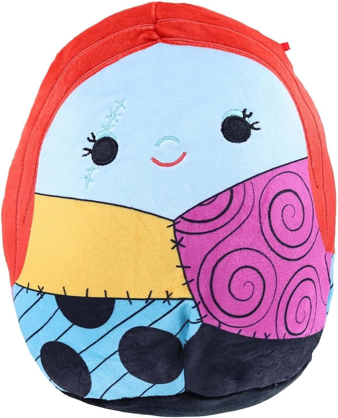 Sally-shaped Squishmallow with orange hair and blue skin and a quilted patchwork patterned outfit