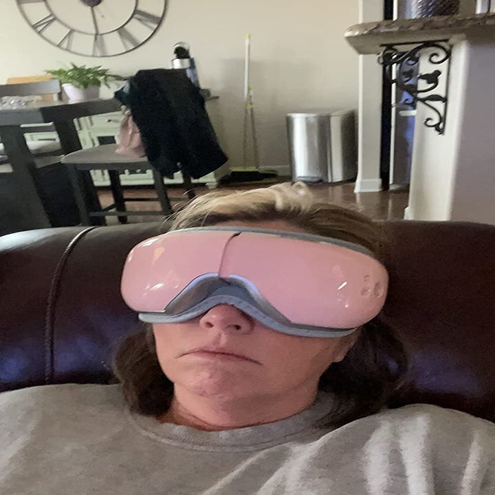 Reviewer wearing pink over eye massager mask