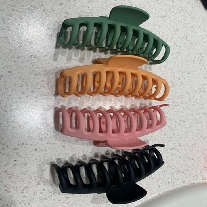 four big hair clips in green, blue, pink, and black