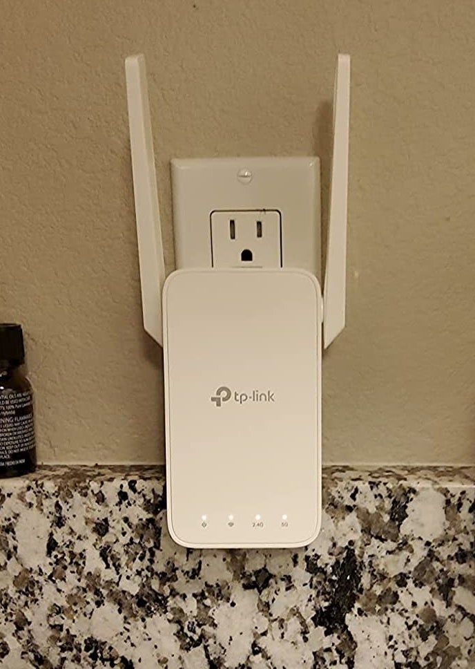 a reviewer photo of the wi-fi extender plugged in to a wall outlet