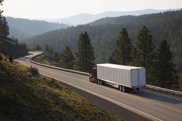 Semitruck driving on a narrow two-lane picturesque highway