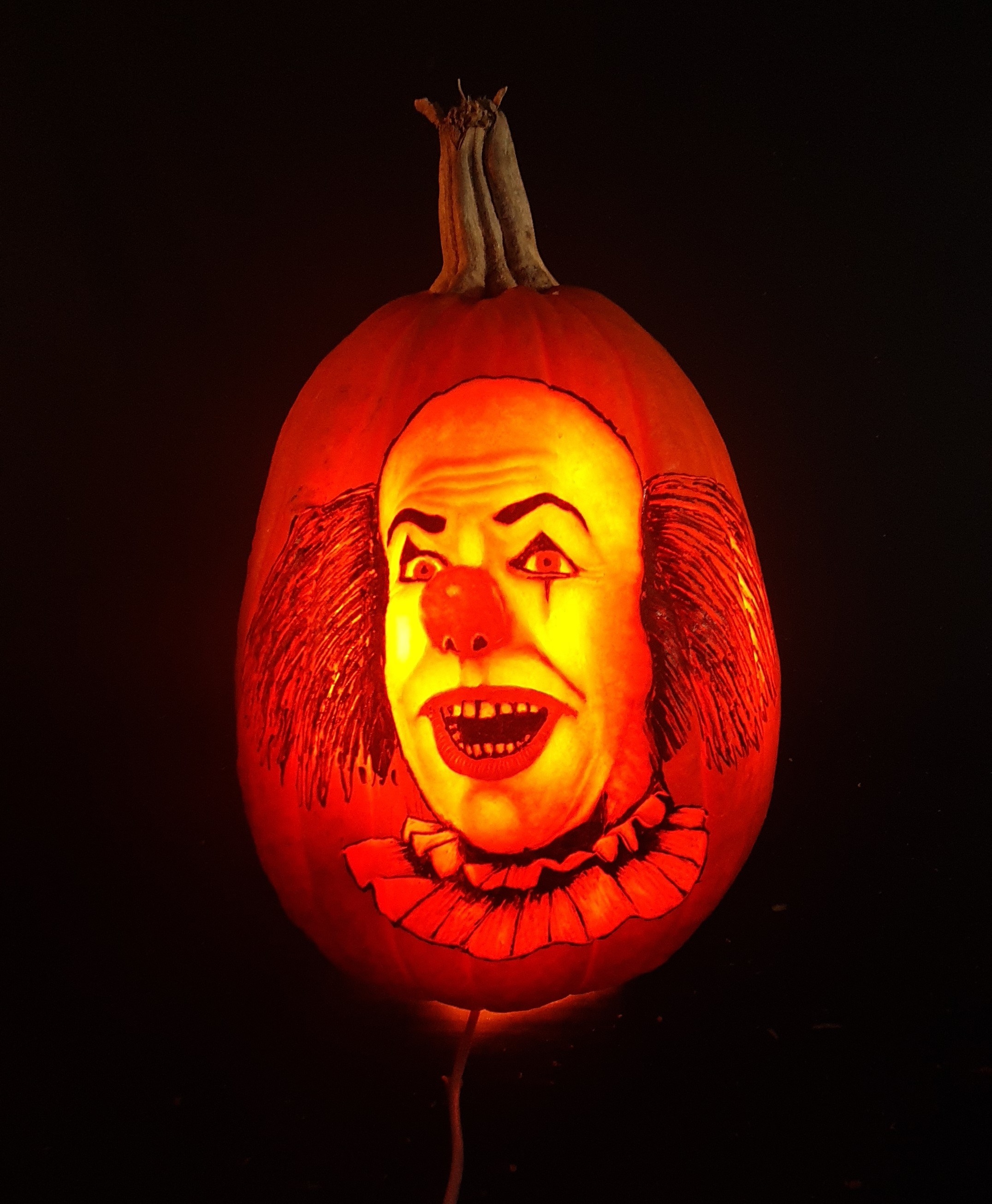 Tim Curry as Pennywise carved on a pumpkin