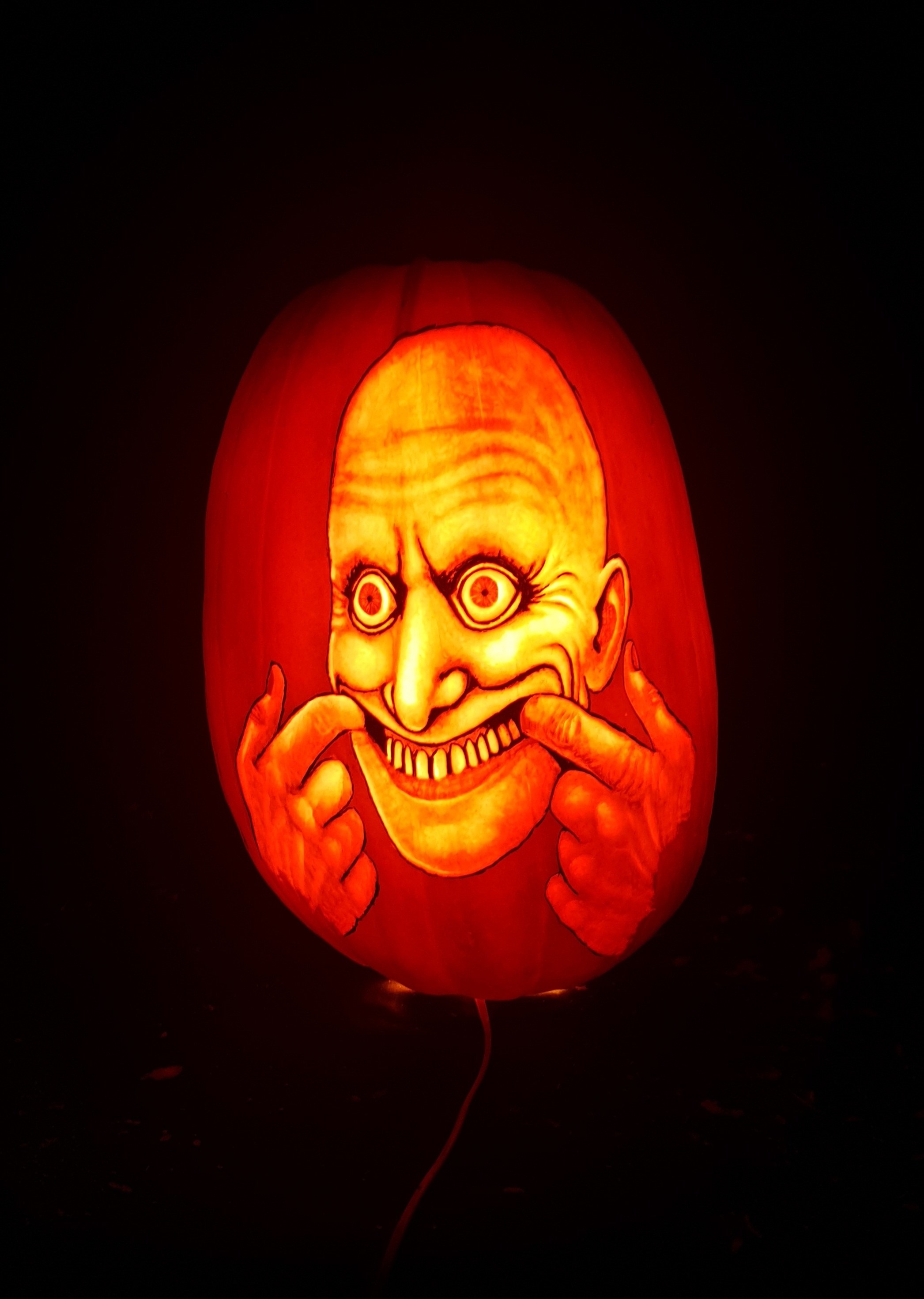 a scary character smiling carved on a pumpkin