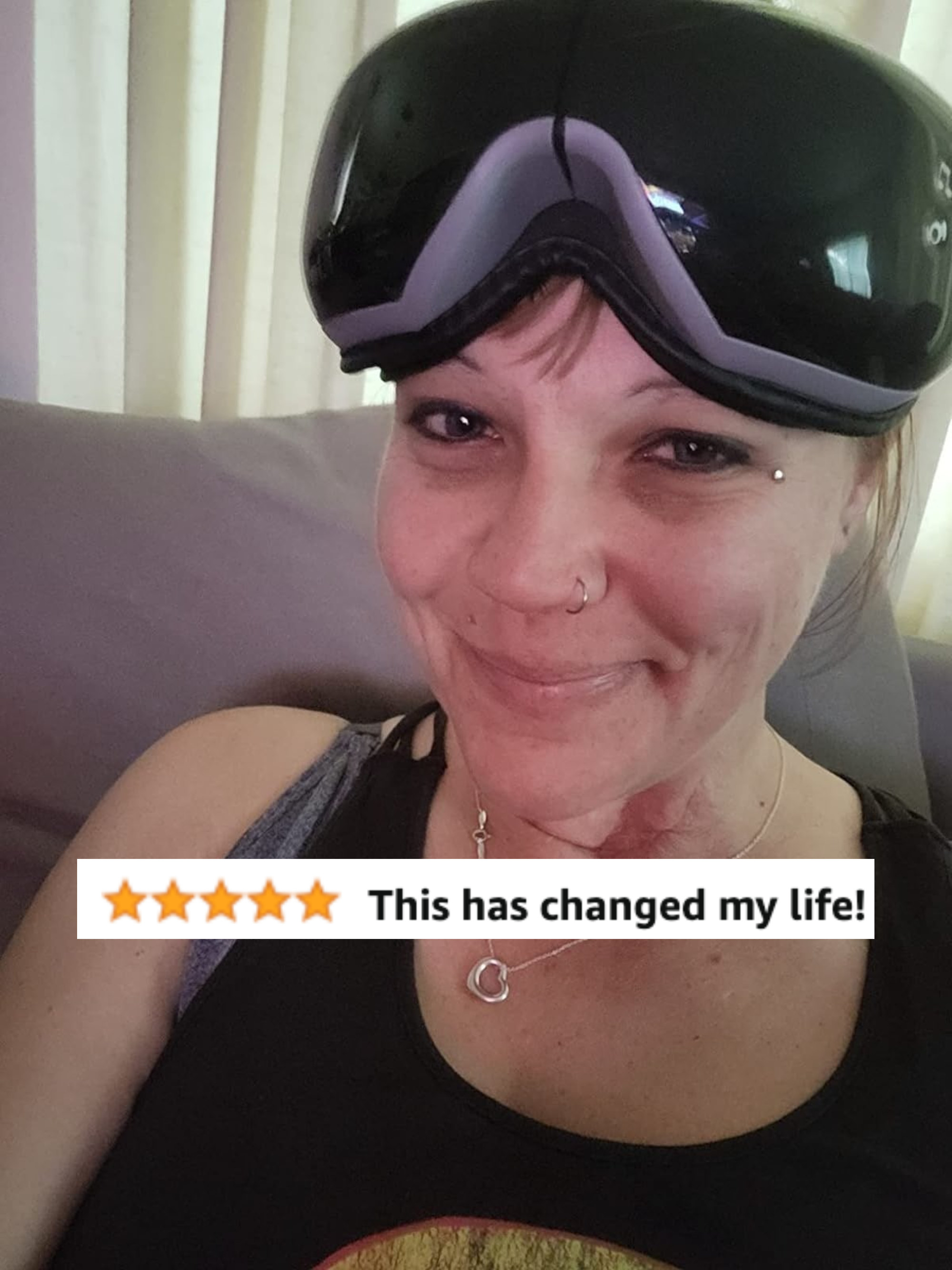 Reviewer wearing black over eye massager mask with five-star review text &quot;this has changed my life&quot;