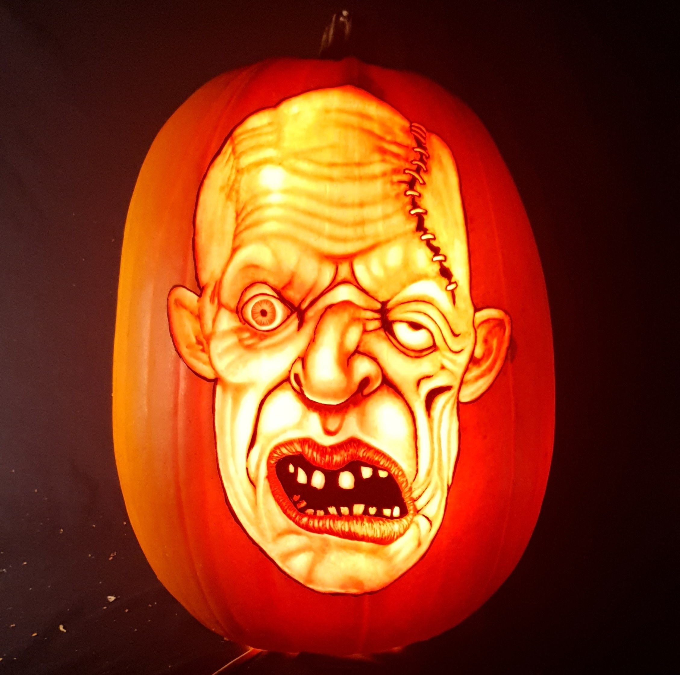 a disfigured face carved on a pumpkin