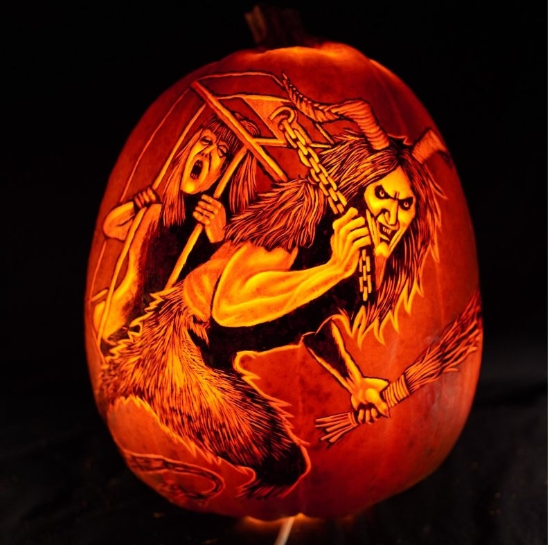 Krampus carrying a naughty child in a cage carved on a pumpkin