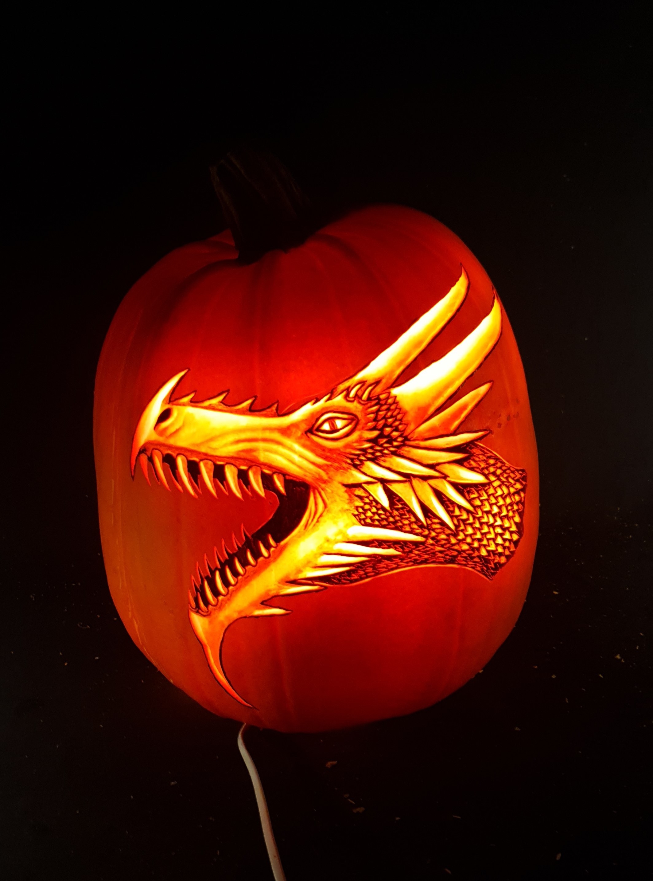 a dragon head carved on a pumpkin
