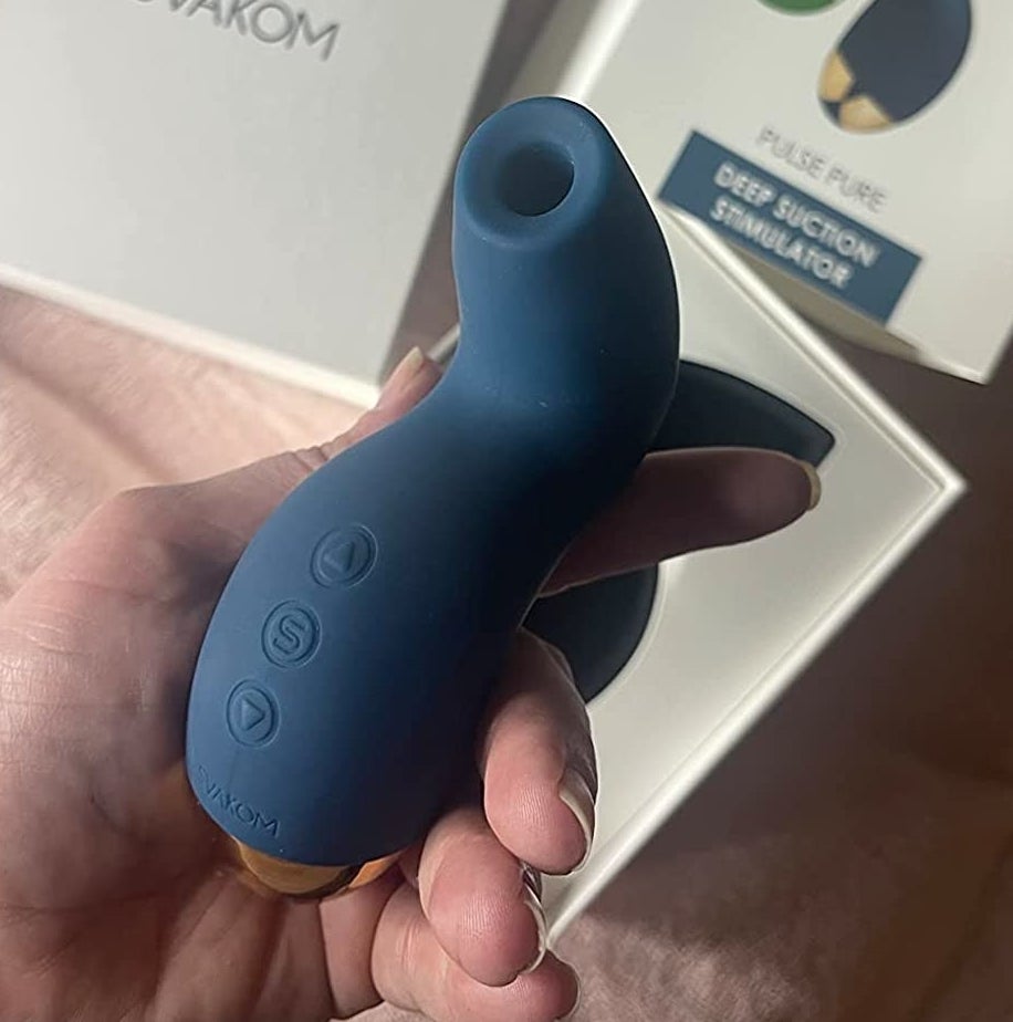 Reviewer holding blue suction vibrator