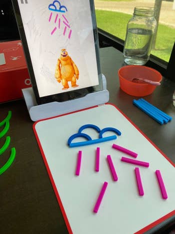 app on propped up tablet with building toys recreating what's on screen