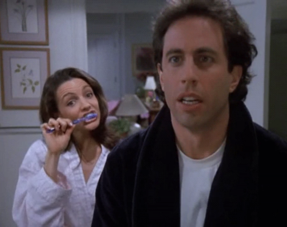 Jerry Seinfeld looking in horror at Kristin Davis brushing her teeth on Seinfeld