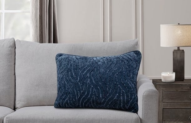 Navy throw pillow on a gray sofa